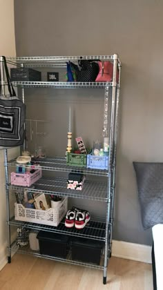 a metal shelving unit with shoes and bags on it