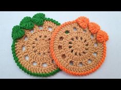 two crocheted fruit coasters sitting on top of a white table next to each other