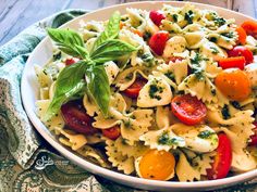 a bowl filled with pasta and vegetables on top of a table