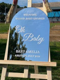 a welcome sign for the baby to be held in front of a blue sky background