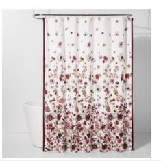 a shower curtain with flowers on it and a white tub in the corner next to it