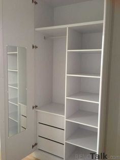 an empty white closet with shelves and mirrors