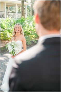 a bride smiles as she walks down the aisle to her groom at their outdoor wedding ceremony