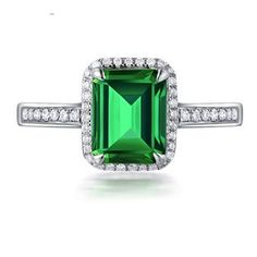 an emerald and diamond ring on a white background with diamonds around it, in the shape of a square