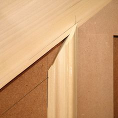 an unfinished piece of wood sitting on top of a wooden floor next to another piece of plywood