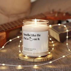 a candle sitting on top of a table next to a string of lights and a guitar