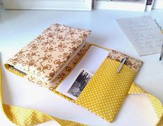 a yellow and white polka dot covered binder next to an open notebook on a table