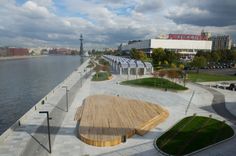 an aerial view of a boardwalk next to a body of water with buildings in the background