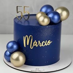 a blue and gold birthday cake with some balls on the top that says marco