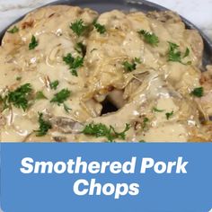 a pan filled with meat covered in gravy next to a blue sign that says smothered pork chops