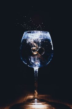 a glass filled with water on top of a wooden table