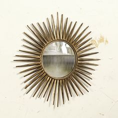 a sunburst shaped mirror hanging on the wall