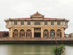 an old building sitting on the side of a river