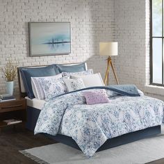 a bed with blue and white comforters in a room