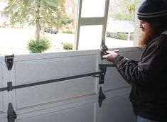 a man is opening the garage door and looking at something