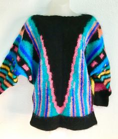 THIS IS A STUNNING HAND DESIGNED AND HAND KNIT ~ ITALIAN MOHAIR SWEATER ~ JUMPER ~ IN A SIZE MEDIUM. A TYPICAL MEDIUM! IT IS A MEDIUM WEIGHT AND THE YARN IS A MEDIUM PLY. IT IS A GEOMETRIC DESIGN OF FABULOUS VIBRANT COLORS ON A BLACK BACK ROUND. IT IS A FLATTERING AND THINNING DESIGN. I PURCHASED THIS JUMPER AS THEY SAY IN LONDON, ENGLAND AT COVENT GARDENS IN THE 1980’S. FOR REAONS OF CUSTOMS I CLIPPED THE DESIGNER LABEL FROM THE SWEATER. IT WAS FROM A HIGH END YARN SHOP IN CONVENT GARDEN THAT F Oversized Retro Acrylic Sweater, Multicolor Long Sleeve Sweater With Geometric Pattern, Multicolor Geometric Pattern Long Sleeve Sweater, Oversized Multicolor Vintage Sweater, Multicolor Mohair Sweater With Crew Neck, Multicolor Mohair Crew Neck Sweater, Multicolor Mohair Sweater For Winter, Multicolor Mohair Sweater For Fall, Vintage Multicolor Acrylic Sweater