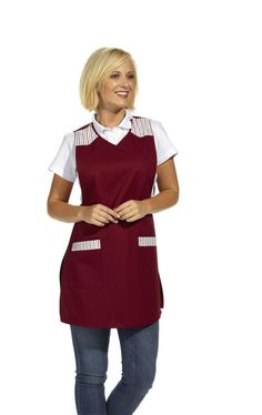 a woman standing with her arms crossed and smiling at the camera, wearing an apron