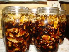 three jars filled with food sitting on top of a table next to a wooden cutting board