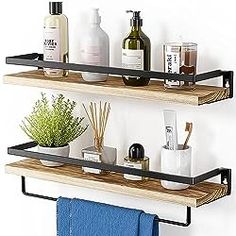 two wooden shelves with black metal brackets holding soap, lotion and other bathroom items