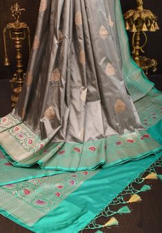 This elegant Steel Gray Tone saree showcases a contemporary interpretation of Banaras' classic weaving techniques. Adorned with intricate Damask zari buttas throughout the body, it is accompanied by a vibrant meenakari Zari floral Cyan Blue border and pallu, infusing the luxurious silk fabric with a pop of color. If you admire a unique blend of design, texture, and shades, this saree will captivate your senses. SILK MARK CERTIFIED This saree is ready to wear with fall and pico done. Handmade silk tassels adorn the pallu and add more grace to it. An unstitched blouse fabric is included. *Note: There may be minor variations in the shade, the texture of the product. Hues/textures show differently due to variations in screen settings and other factors, *Note: This saree is woven of pure natura Banarasi Katan Silk Saree, Design Texture, Katan Silk Saree, Blue Border, Cyan Blue, Katan Silk, Sari Fabric, Handmade Gift Wrap, Steel Grey