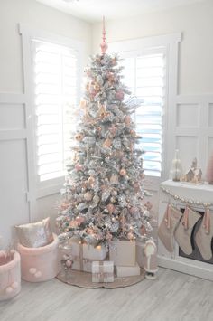 a white christmas tree with pink and silver decorations