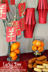 there is a vase with oranges in it and some paper decorations on the wall