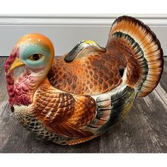 a ceramic turkey sitting on top of a wooden floor