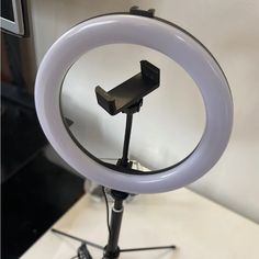 a white ring light sitting on top of a tripod