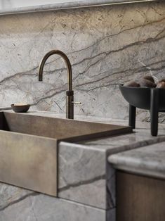 a kitchen sink sitting next to a counter top under a faucet with two bowls on it