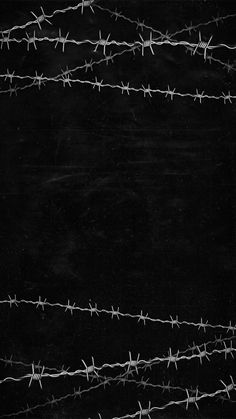 black and white photograph of barbed wire on dark background with space for text or image