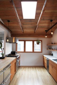 a kitchen with wood floors and wooden ceiling