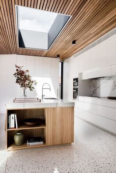 a modern kitchen with white cabinets and marble counter tops is featured in this image from the magazine