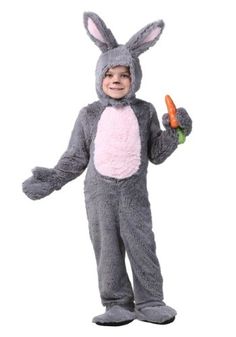 a little boy in a bunny costume holding a carrot