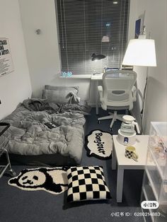 a room with a bed, desk and chair in it that has a black and white checkered rug on the floor