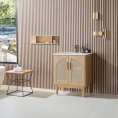 a white toilet sitting next to a bath tub in a bathroom under a window with striped walls