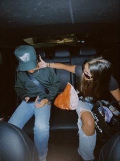 two people sitting in the back of a car with their hands on each other's hips