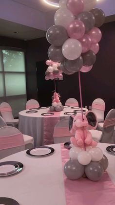 a table set up with balloons and stuffed animals for a baby's first birthday party