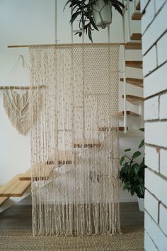 a room with a bed and some plants on the wall next to a stair case