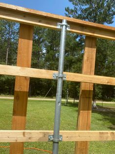 an image of a wooden fence with metal pipes attached to the top and bottom posts