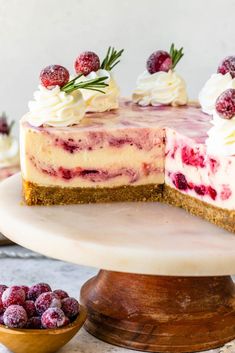 a cheesecake with raspberries and whipped cream is on a cake platter