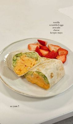 a burrito with guacamole and strawberries on a plate