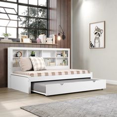 a white bed with drawers underneath it in a room