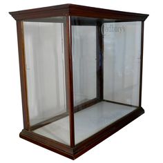 an empty glass display case with wood trimmings on the front and sides, against a white background