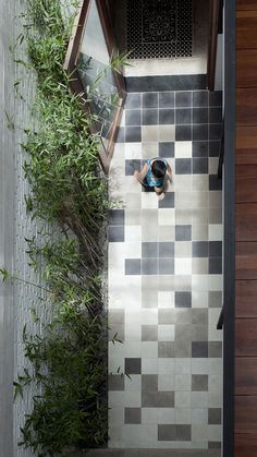 an overhead view of a person standing on a tiled floor next to a planter