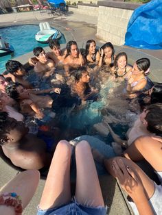 a group of young people sitting around a pool in the middle of a swimming pool