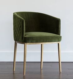 a green chair sitting on top of a hard wood floor next to a white wall