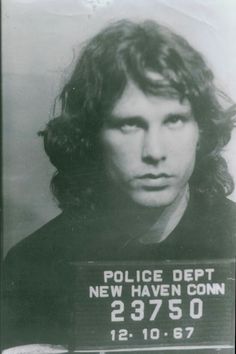 an old mug shot of a man with long hair holding a sign that says police dept new haven conn