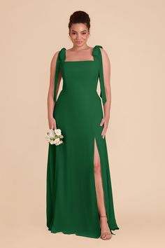 a woman wearing a green dress with one side slit