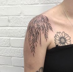 a woman's arm with a flower and bamboo tree tattoo on her left shoulder