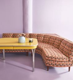 a couch and table in a room with purple walls, checkered upholstered furniture